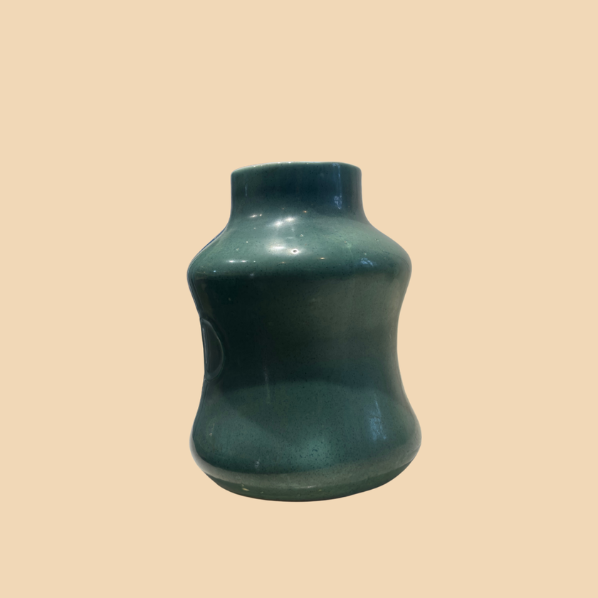 Green ceramic vase on a beige background